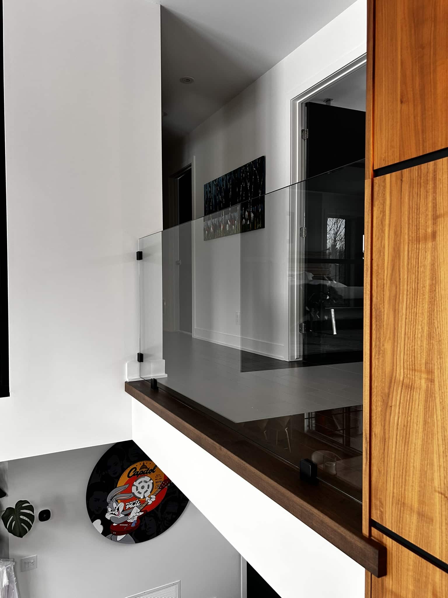 Garde-corps en verre sur mesure installé sur une mezzanine résidentielle moderne, avec fixation noire et finition épurée, projet réalisé sur la Rive-Sud de Montréal.